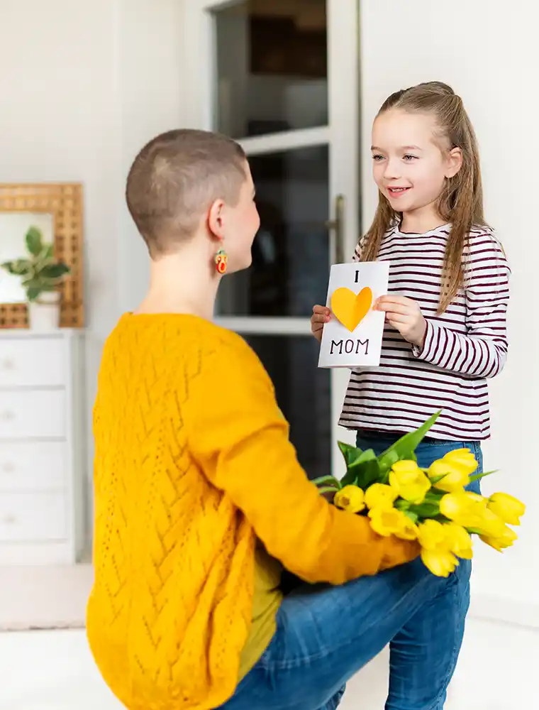 young girl surprising her mom with homemade greeting card | Cancer Prevention Research Trust young girl surprising her mom with homemade greeting card